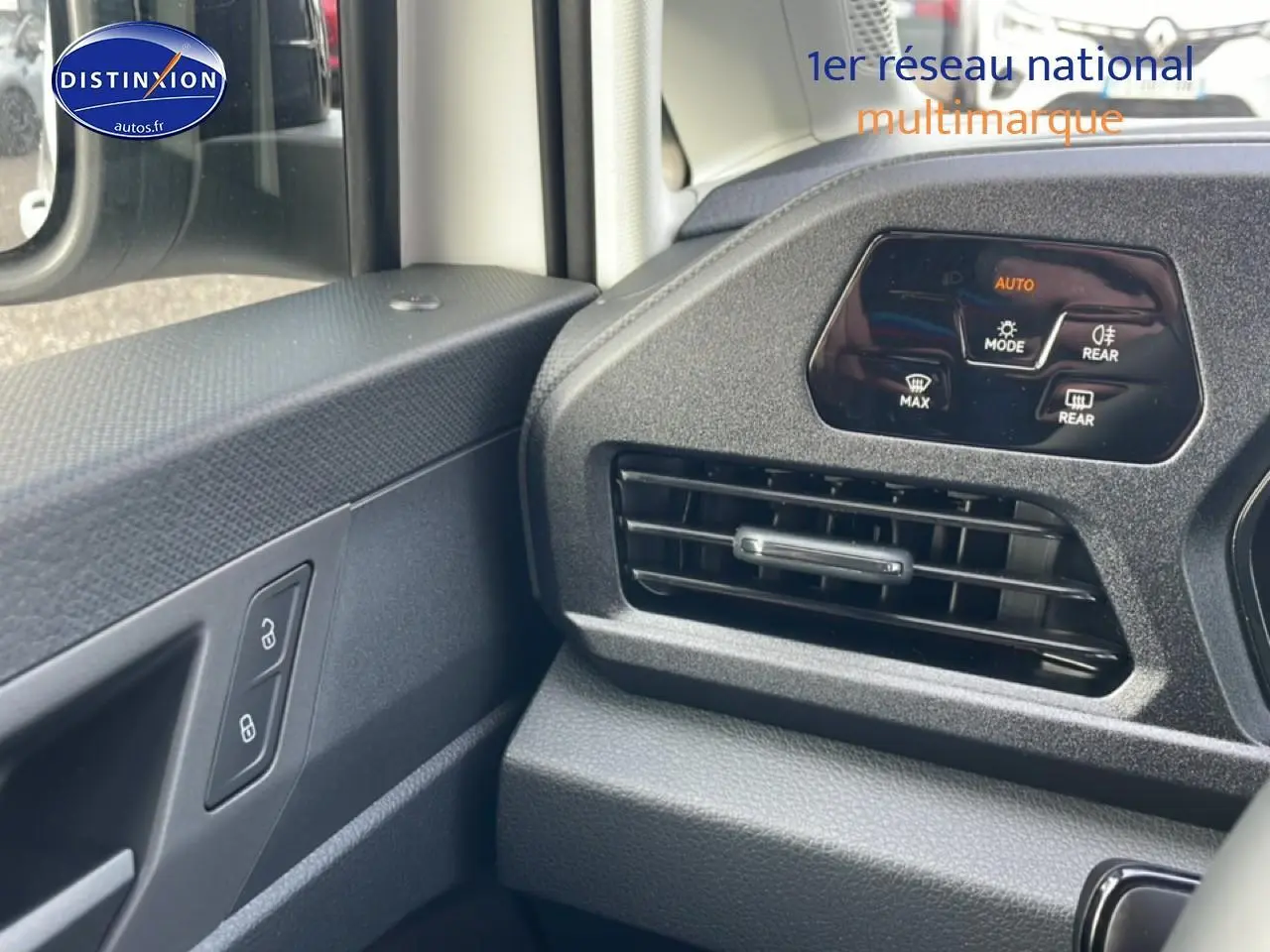 Détail de la console centrale et de la porte côté conducteur du Volkswagen Caddy blanc, avec commandes de climatisation et verrouillage.