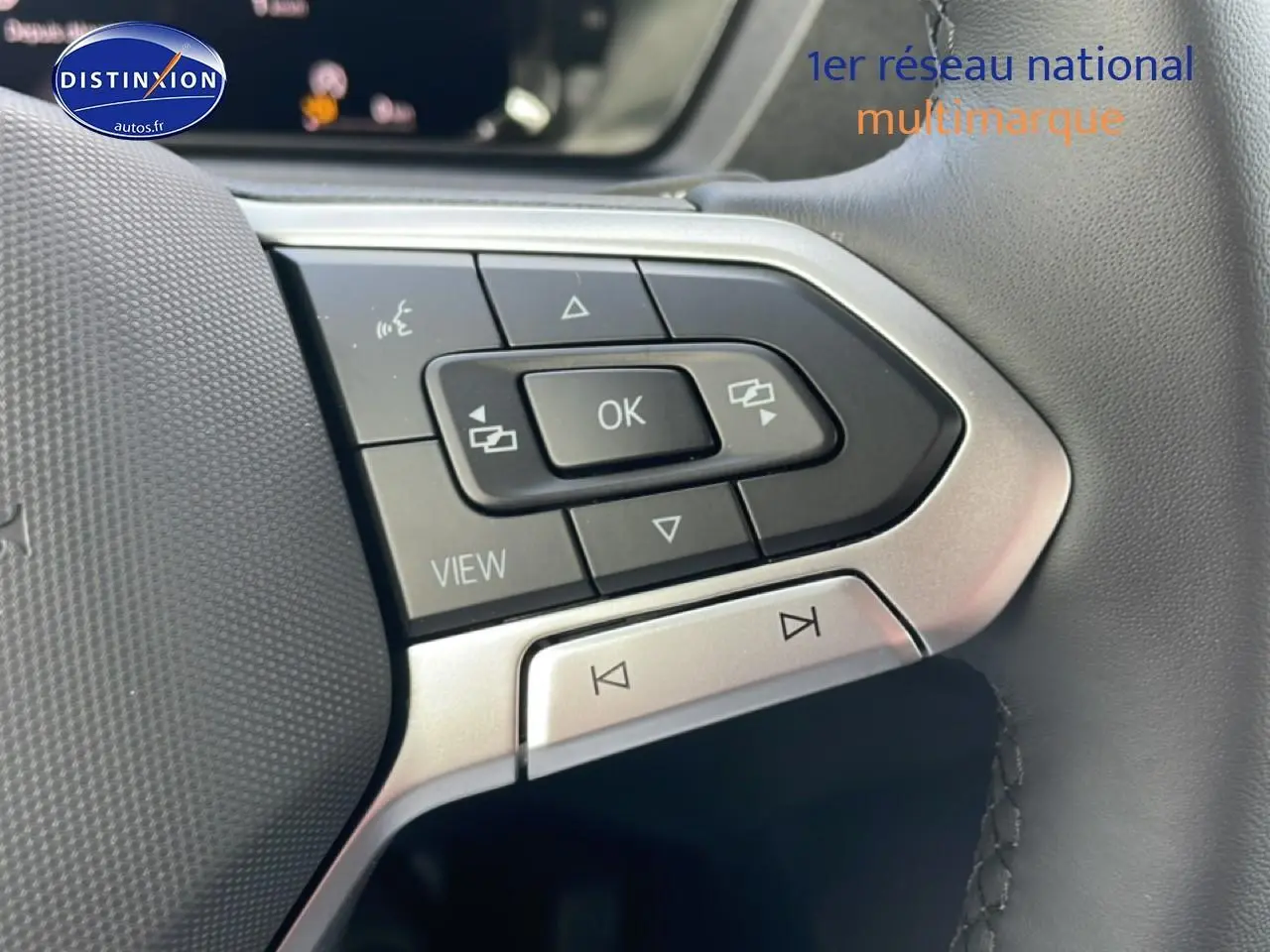 Gros plan sur les commandes gauche du volant cuir multifonction du Volkswagen Caddy blanc 2025.