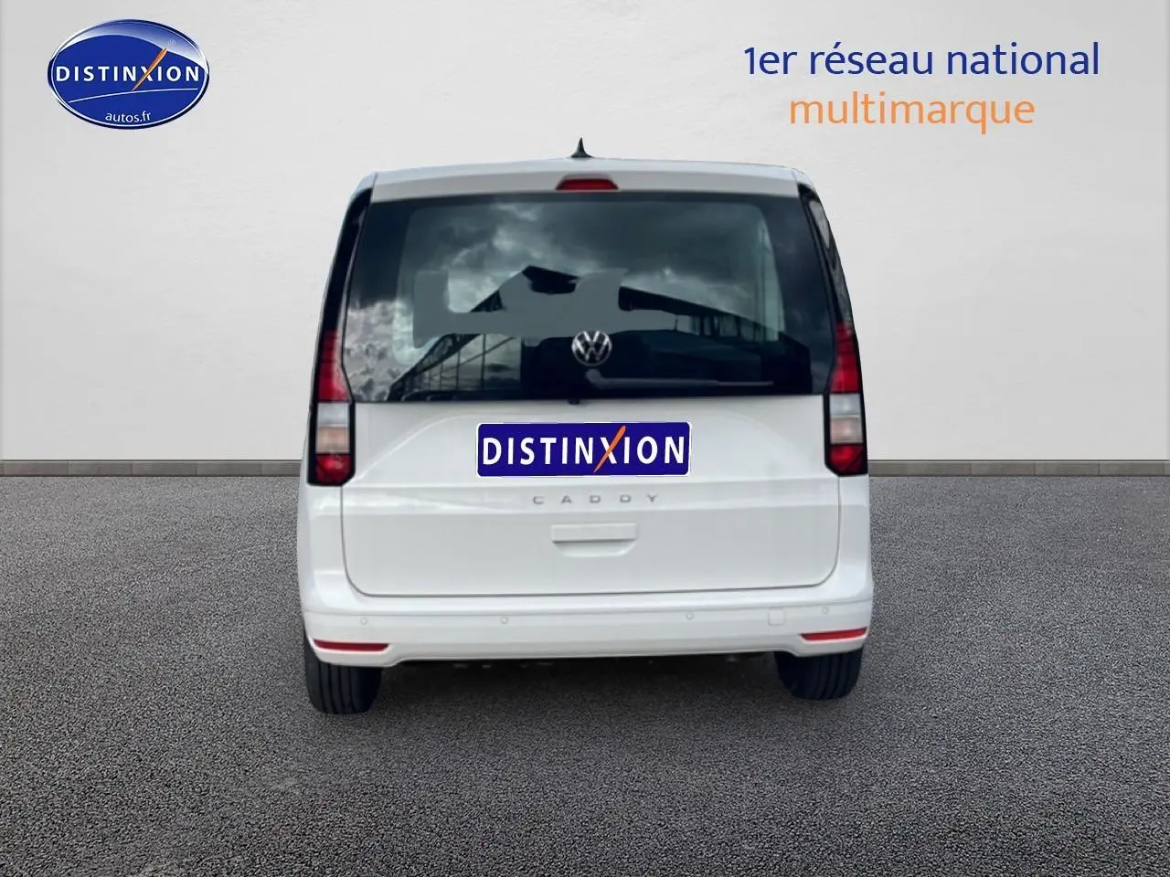 Vue arrière d'un Volkswagen Caddy blanc 2025 avec vitres teintées et feux verticaux rouges.