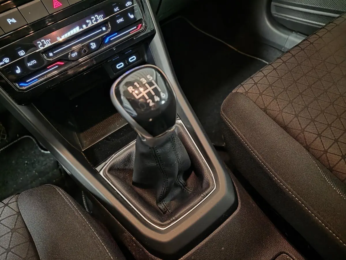 Gros plan sur le levier de vitesses manuel noir et la console centrale du Volkswagen T-Cross 1.0 TSI 110 Active.