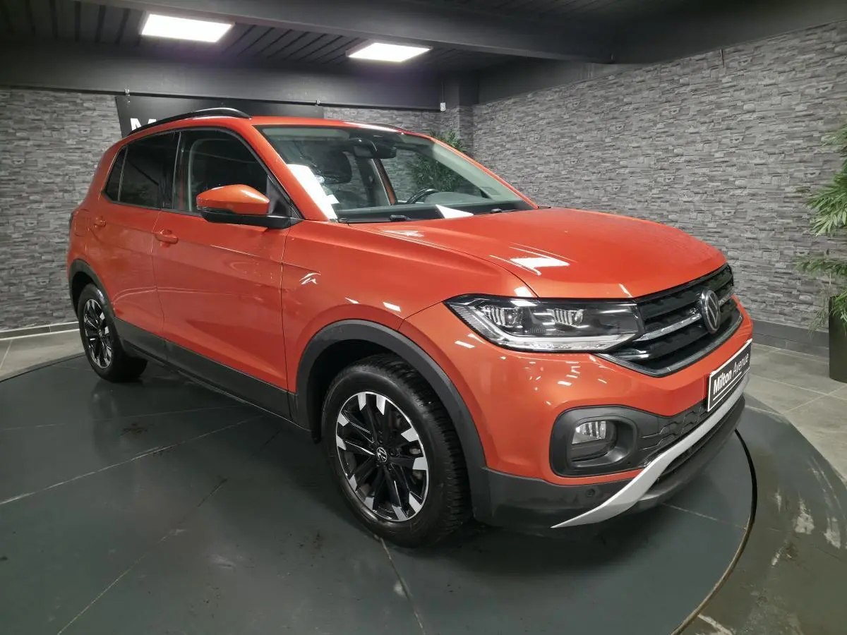 Volkswagen T-Cross orange Energy en 3/4 avant droit, jantes alliage noires et calandre noire avec liseré chromé.