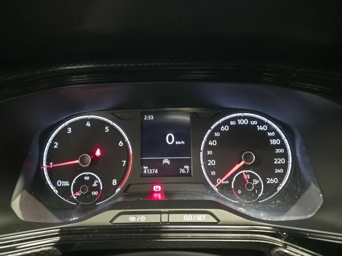 Tableau de bord numérique du Volkswagen T-Cross 1.0 TSI 110 Active, affichant vitesse à 0 km/h et compteurs analogiques.