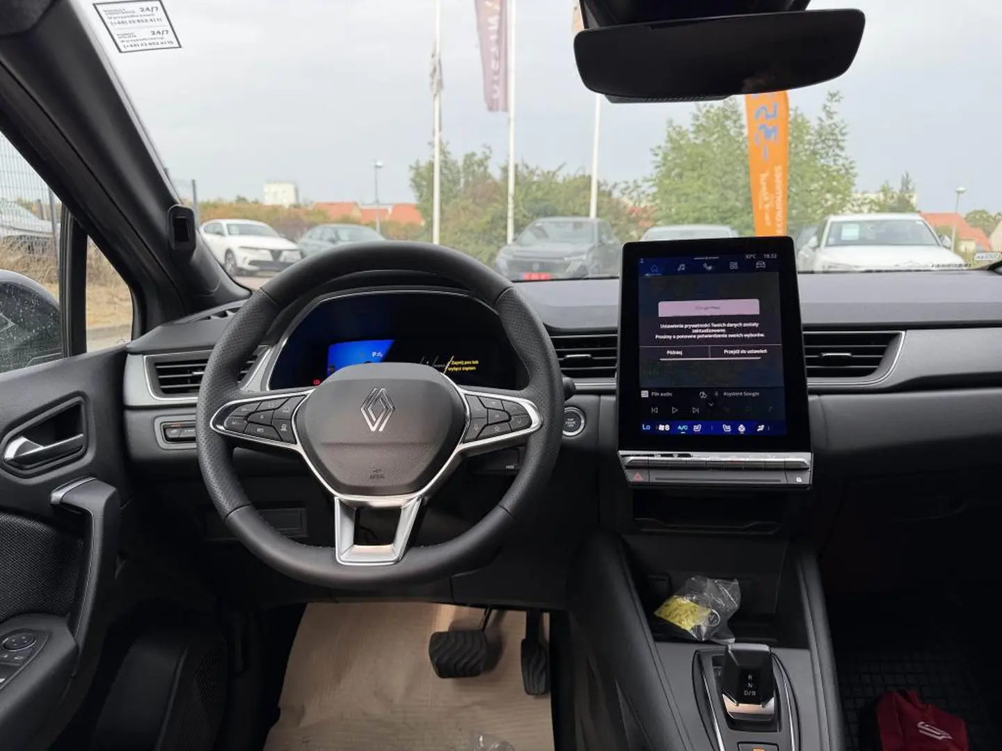 Vue intérieure frontale du poste de conduite gris du Renault Symbioz 2026 avec volant multifonction et écran tactile vertical.