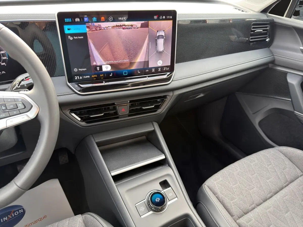 Vue intérieure avant droite du Volkswagen Tiguan 2026, tableau de bord noir avec écran tactile affichant caméra 360 et console centrale moderne.