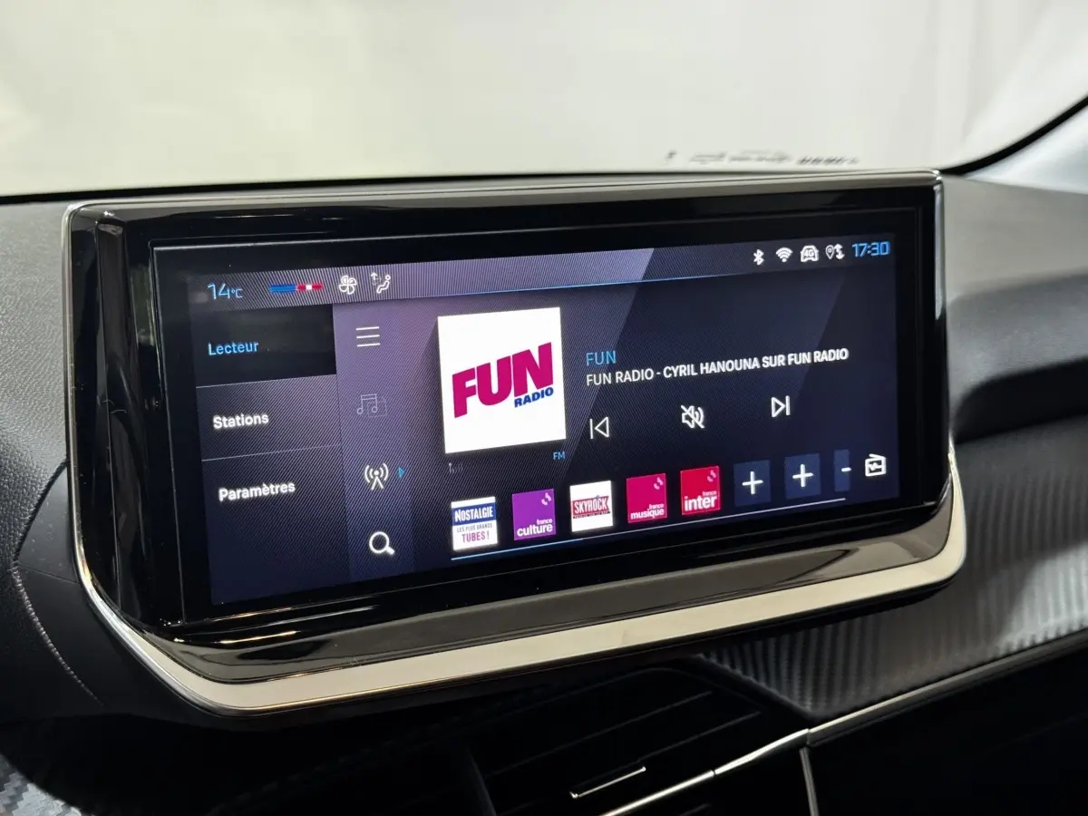 Écran tactile central de la Peugeot 208 PureTech 75 S&S Active 2024 affichant la radio Fun en intérieur noir.