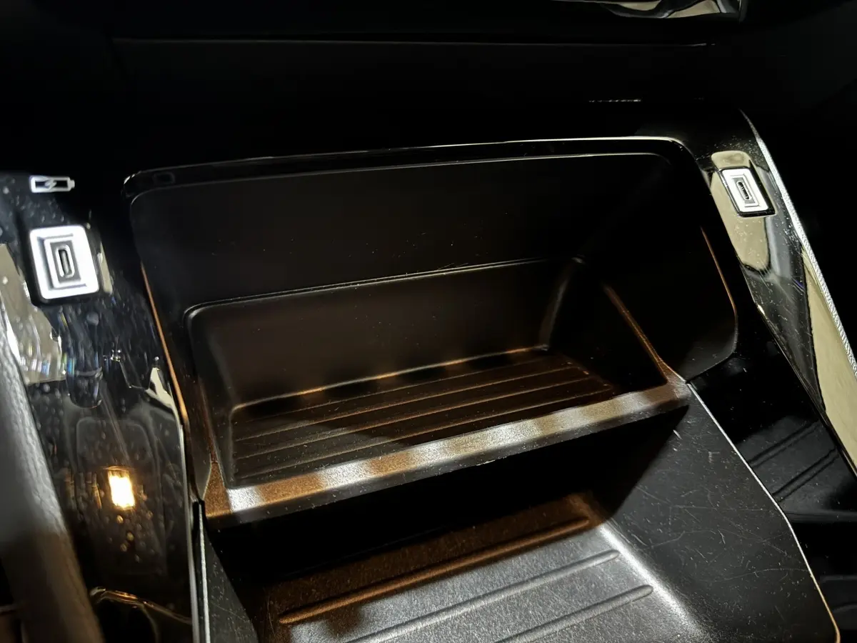 Gros plan intérieur sur le rangement central noir brillant de la Peugeot 208 PureTech 75 S&S Active 2024.