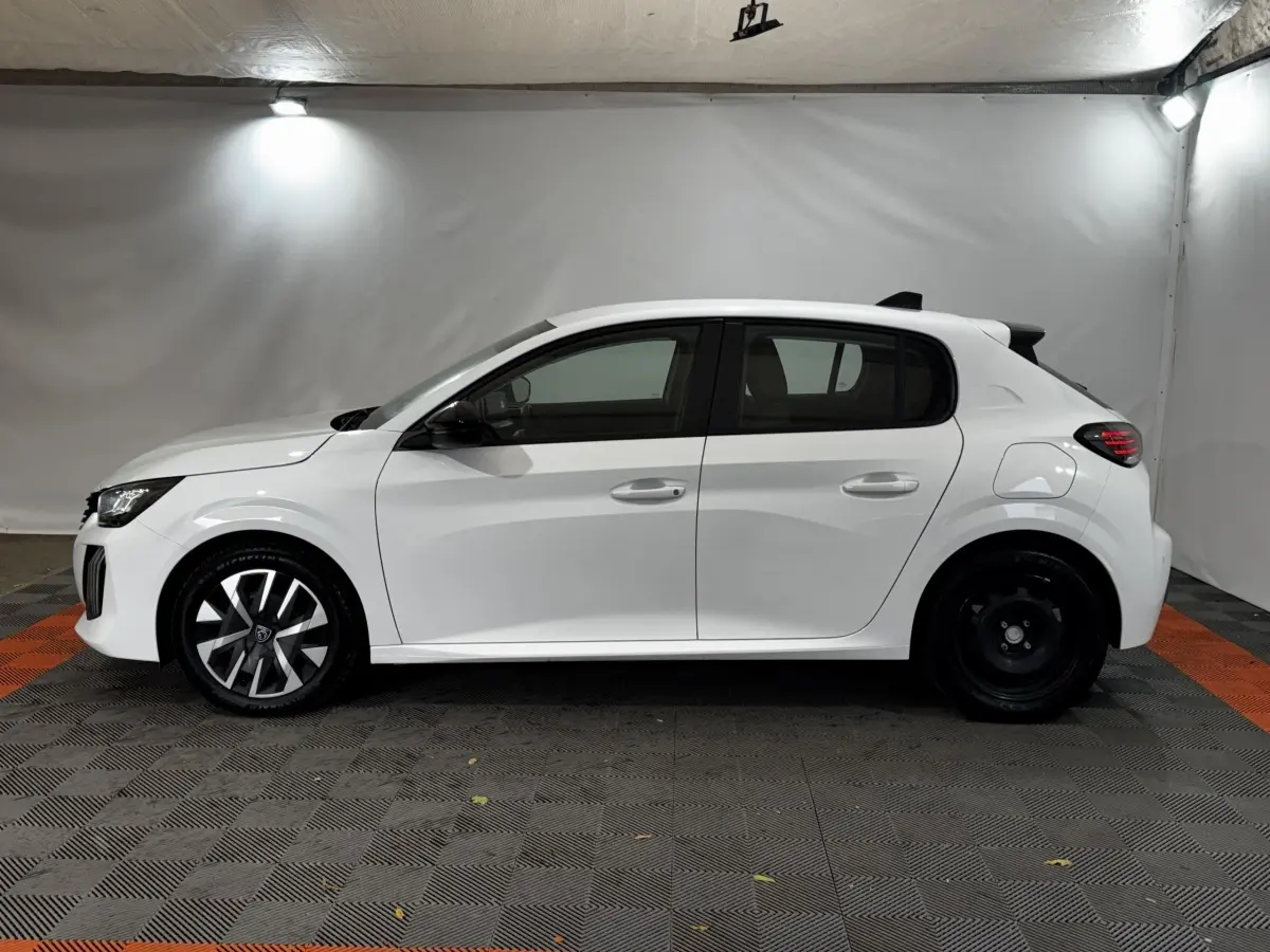 Profil côté gauche de la Peugeot 208 PureTech 75 S&S Active blanche, avec jantes avant stylisées et arrière acier simple.