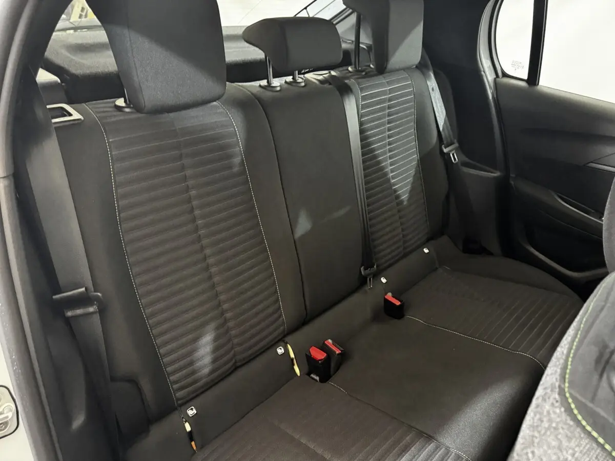 Vue intérieure arrière de la banquette noire de la Peugeot 208 PureTech 75 S&S Active, avec ceintures et appuie-têtes.