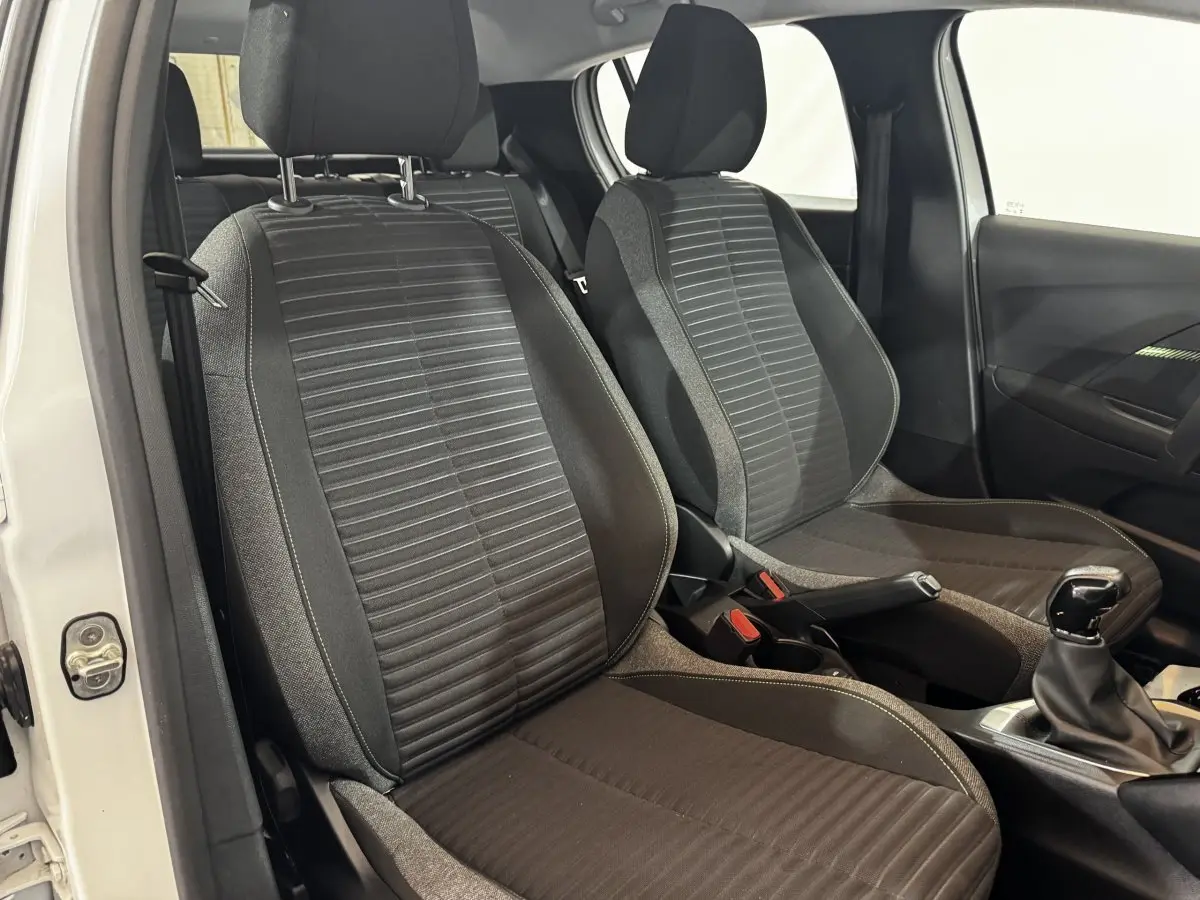 Vue intérieure des sièges avant en tissu noir et gris de la Peugeot 208 PureTech 75 S&S Active blanche, côté droit.