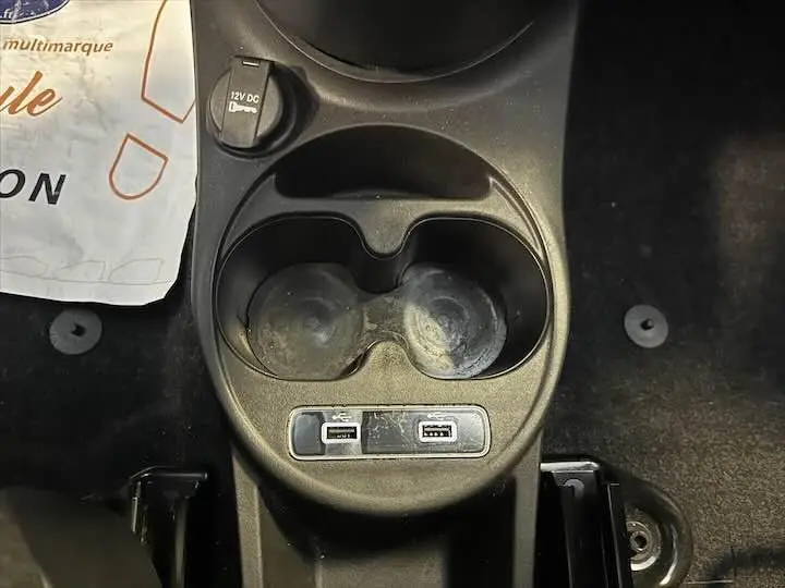 Prise de vue rapprochée du port 12V DC et console centrale noire d'une FIAT 500 rouge 2023.