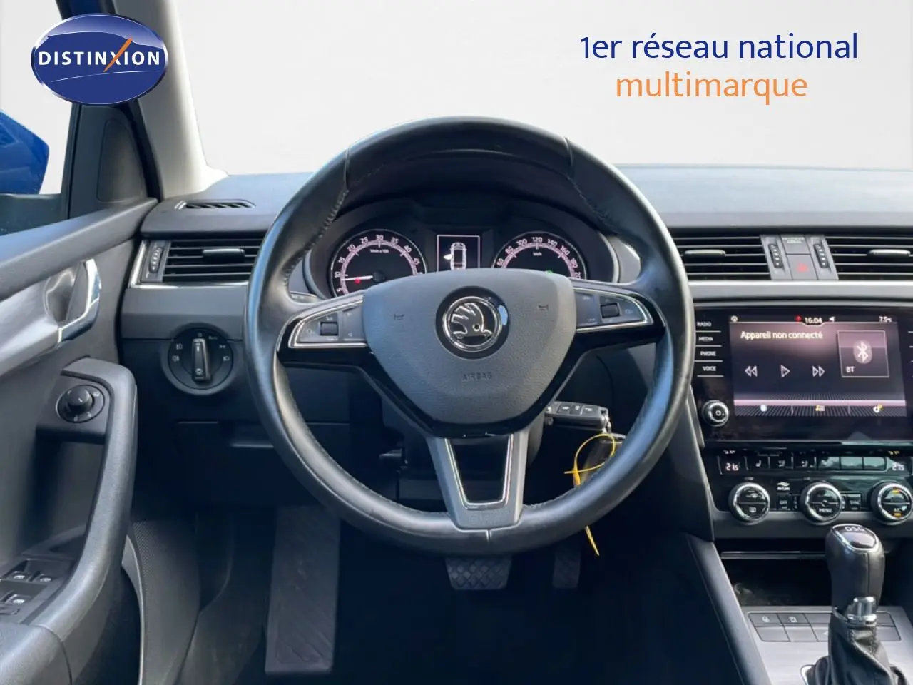 Vue frontale du volant et du tableau de bord noir de la Skoda Octavia Combi 2019 avec écran tactile et commandes au volant.