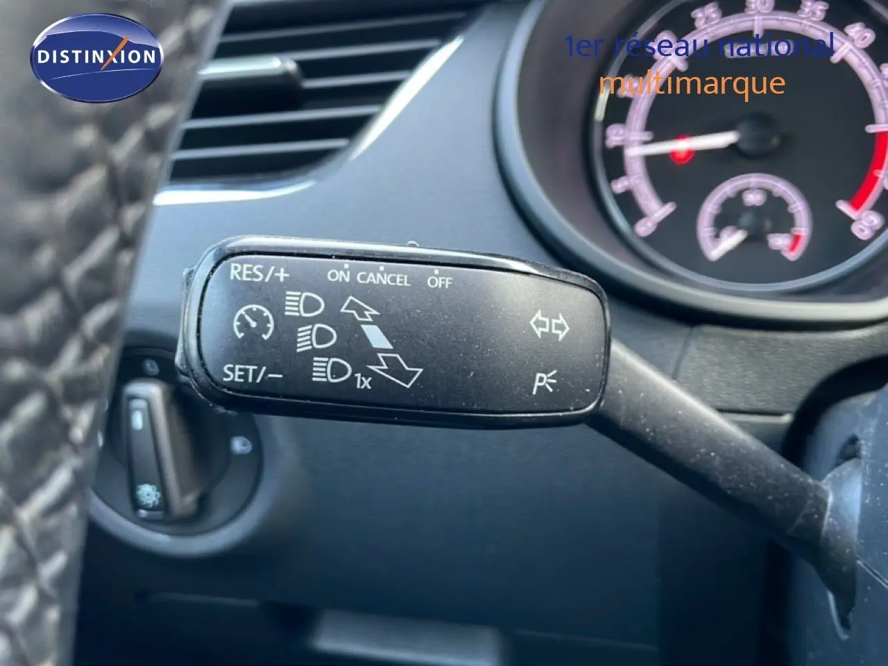 Gros plan sur la commande de régulateur de vitesse à gauche du volant dans l’habitacle d’une Skoda Octavia Combi bleu racing metal.