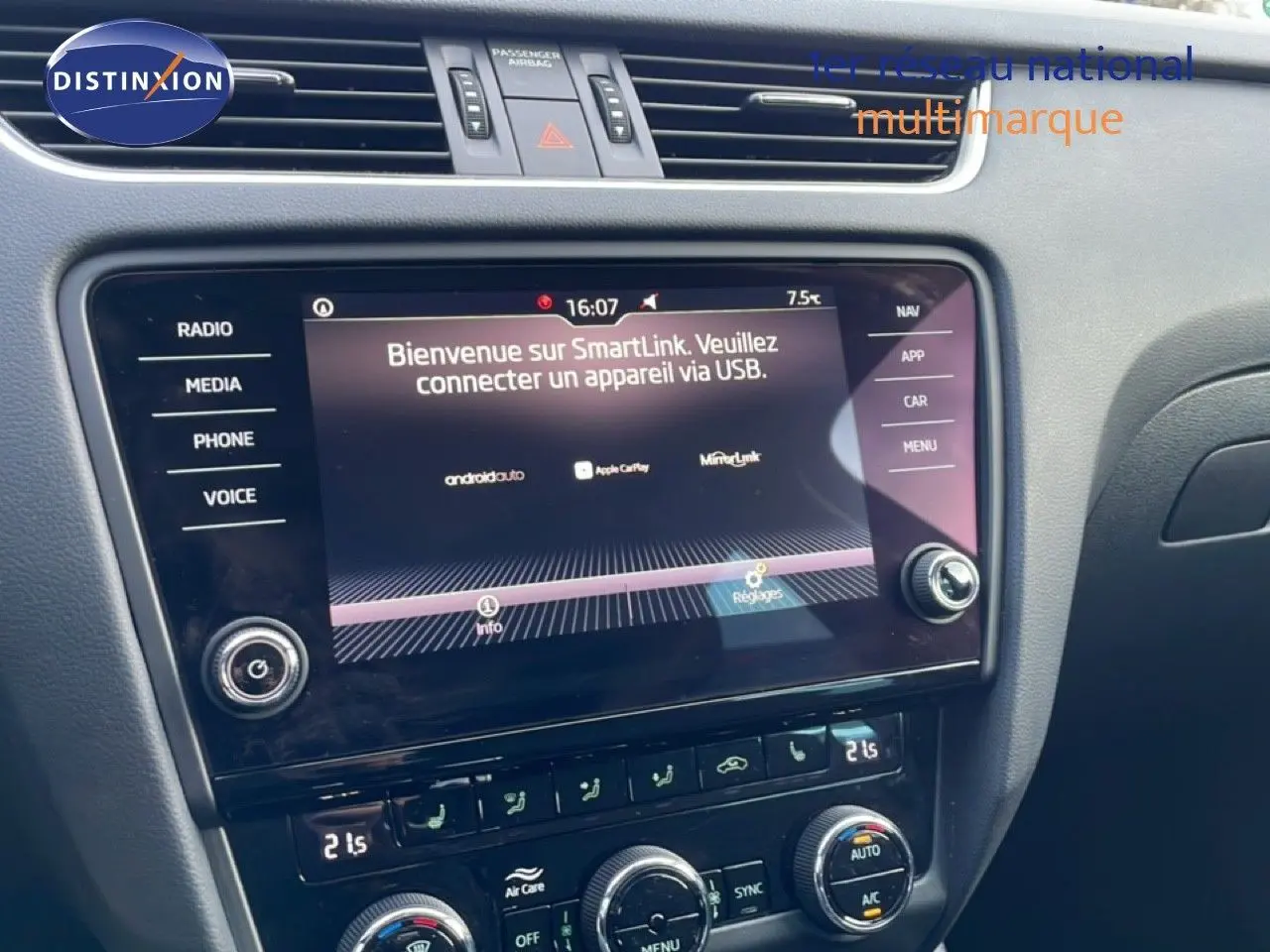Vue rapprochée de la console centrale de la Skoda Octavia Combi 2019, écran tactile avec interface SmartLink et commandes de climatisation.