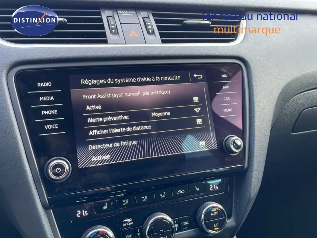 Écran tactile central de la Skoda Octavia Combi 2019 affichant les réglages d’aide à la conduite, avec commandes de climatisation en dessous.