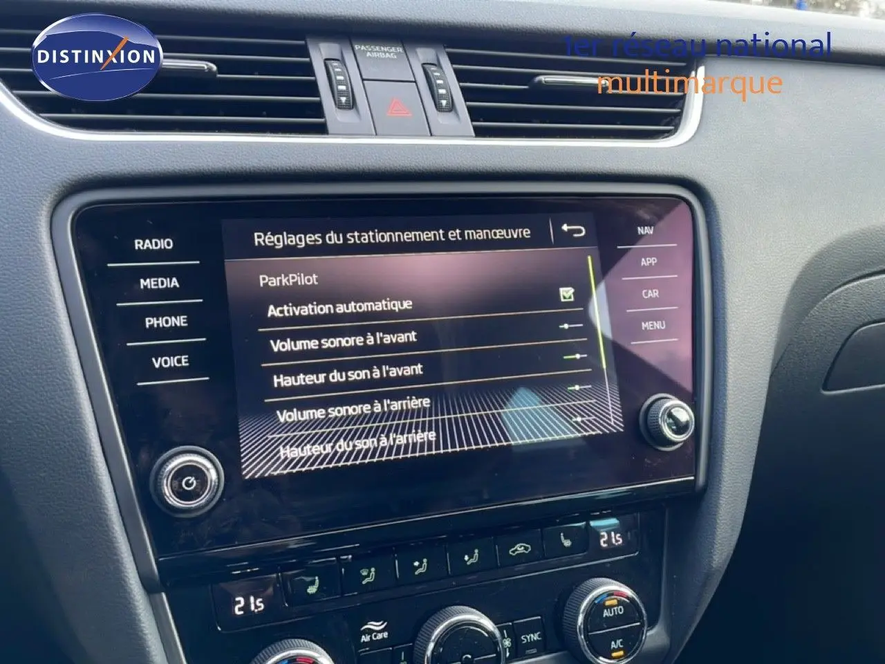 Vue rapprochée de l’écran tactile central et de la console de la Skoda Octavia Combi 2019 bleu racing metal, affichant les réglages ParkPilot.