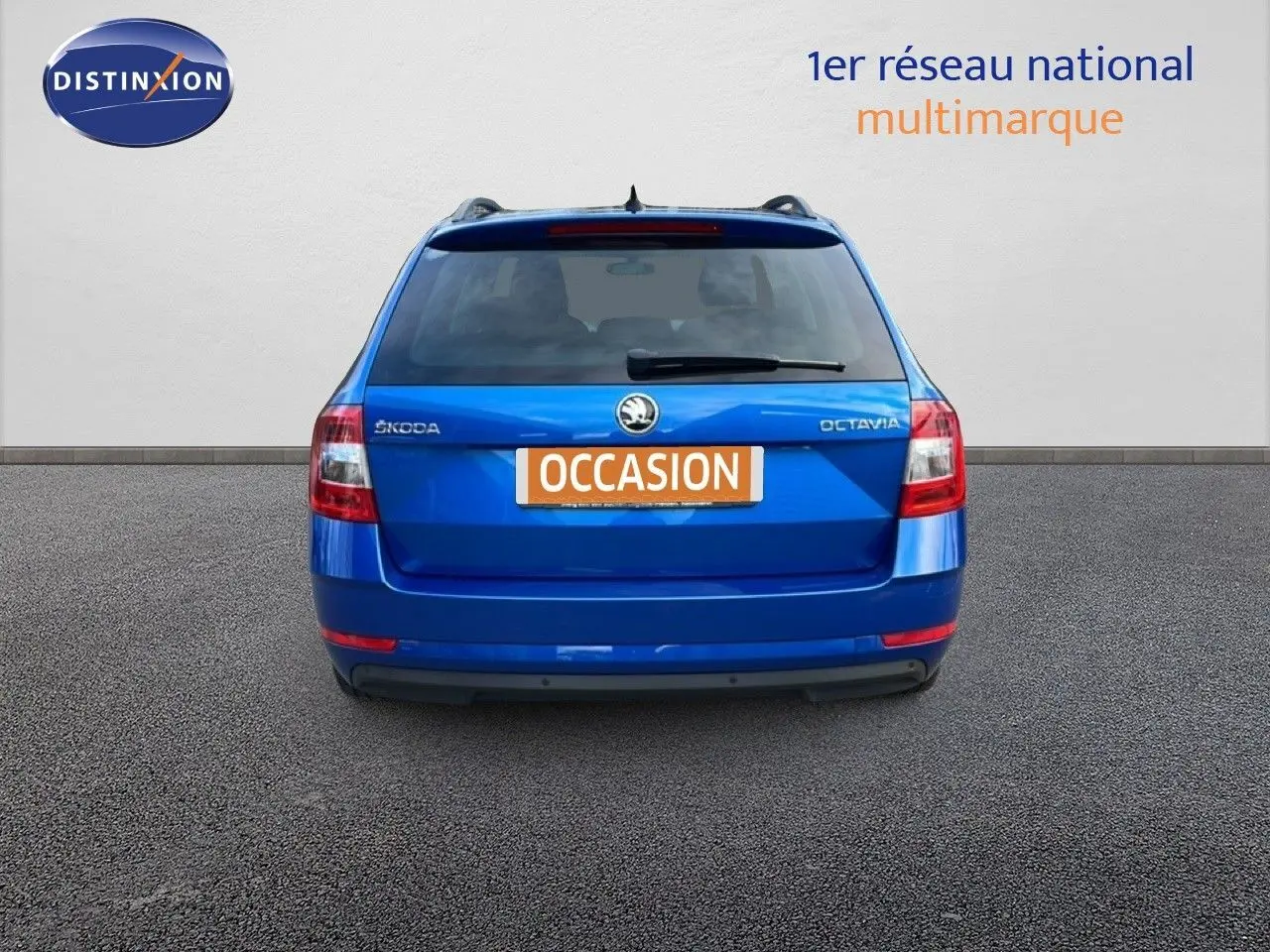 Vue arrière d'une Skoda Octavia Combi bleu racing metal avec plaque "OCCASION" sur fond neutre.