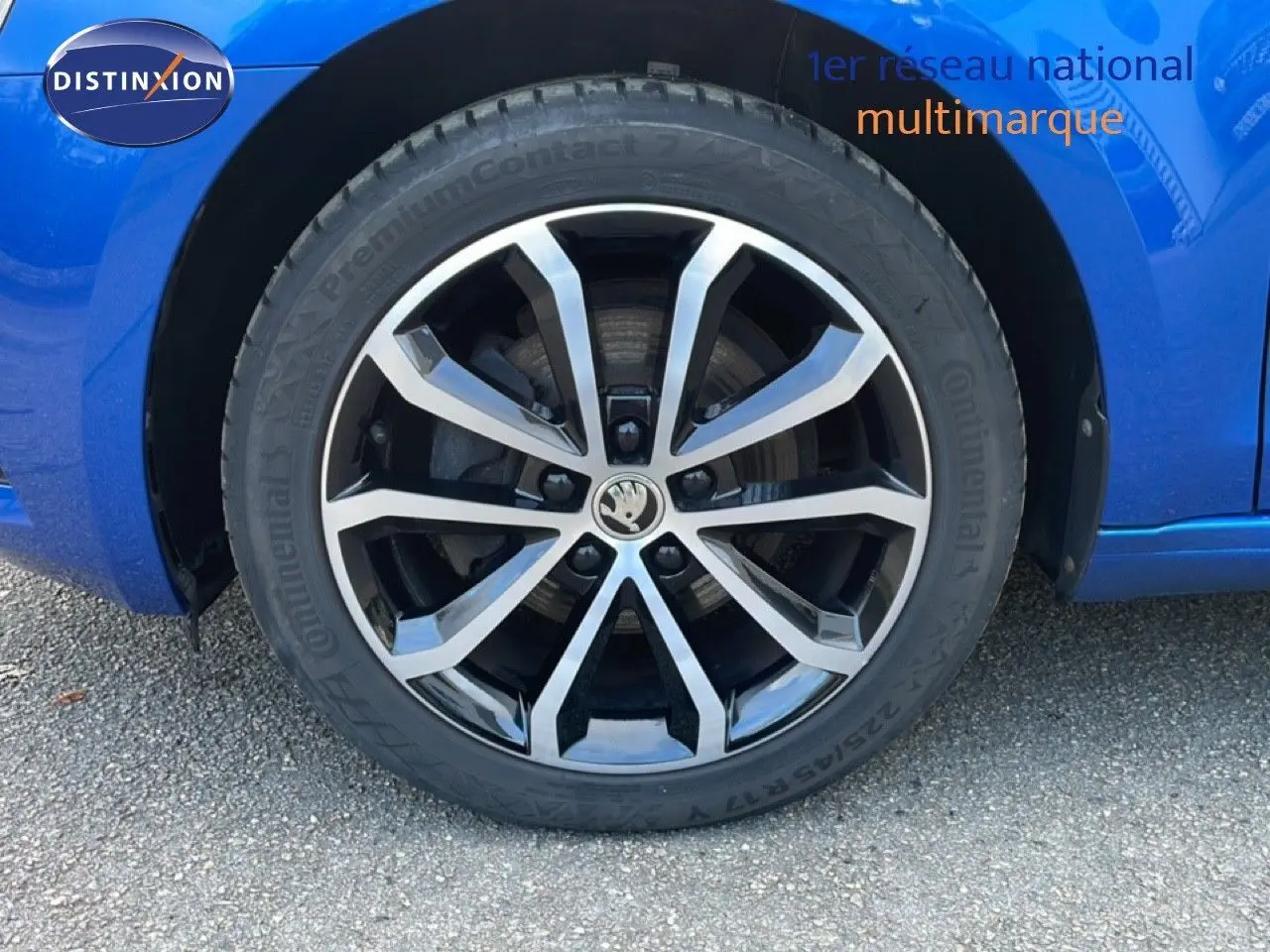 Gros plan sur la roue avant gauche de la Skoda Octavia Combi bleu racing métal avec jante alliage bicolore.