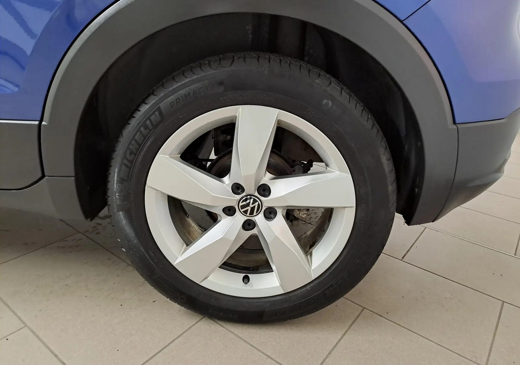 Gros plan sur la roue avant droite du Volkswagen T-Cross Bleu Récif, jante alliage cinq branches et pneu Michelin.