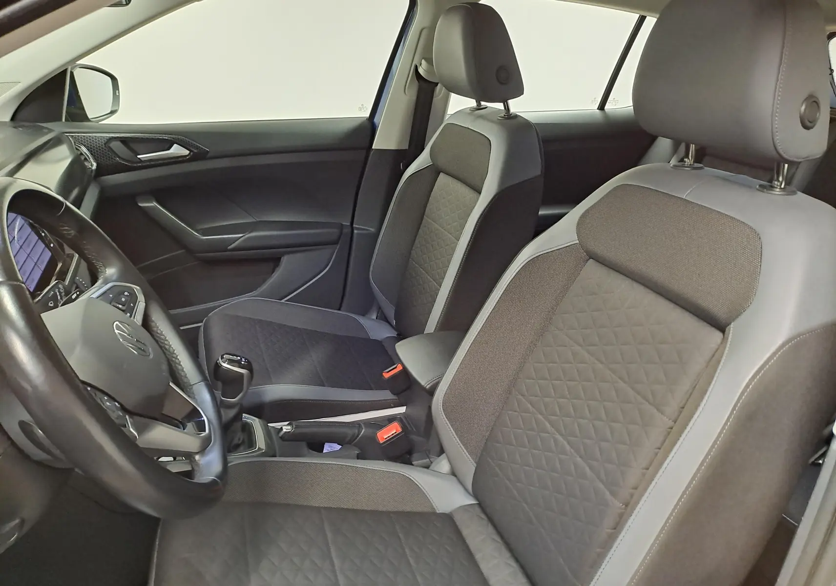 Vue intérieure côté conducteur du Volkswagen T-Cross 2022 avec sièges tissu gris et volant multifonction.
