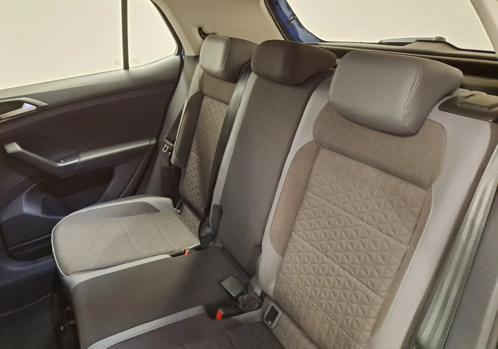 Vue intérieure des sièges arrière du Volkswagen T-Cross 2022, tissu gris avec motifs géométriques, côté gauche visible.