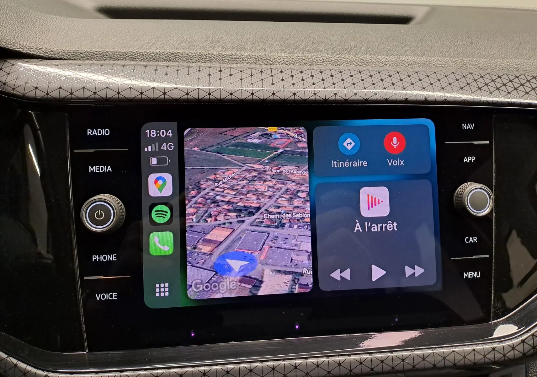 Vue rapprochée de l'écran tactile central du Volkswagen T-Cross 2022 avec navigation et commandes vocales affichées.