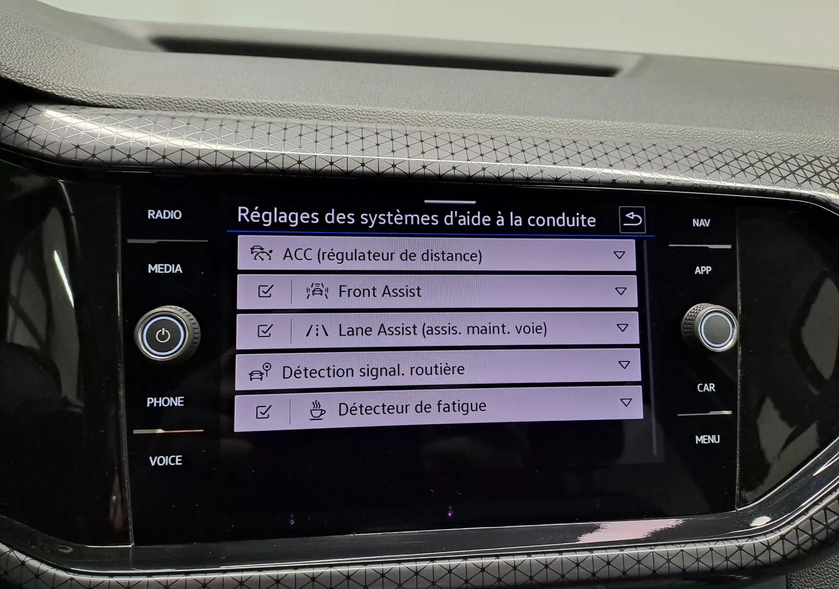 Écran tactile central du Volkswagen T-Cross 2022 affichant les réglages d’aide à la conduite, intérieur noir.