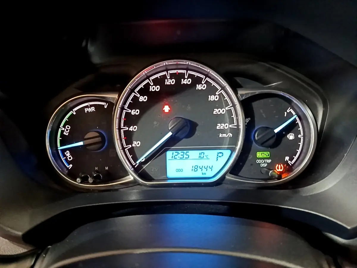 Tableau de bord de Toyota Yaris hybride 2019 montrant compte-tours, vitesse, jauge carburant et affichage digital bleu.