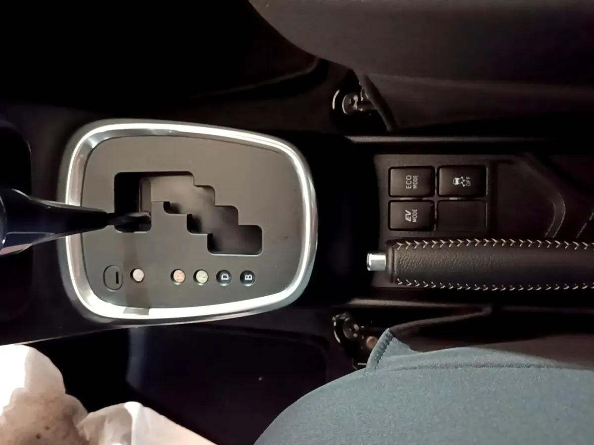 Gros plan sur la console centrale de la Toyota Yaris 2019 hybride, montrant le levier de boîte auto et frein à main cuir.