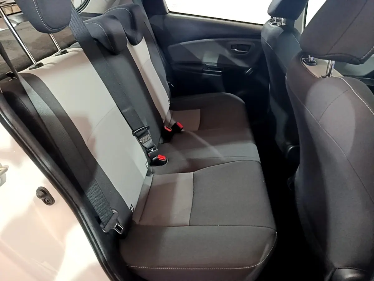 Vue intérieure côté arrière droit montrant la banquette bicolore grise et noire de la Toyota Yaris blanche 2019 hybride
