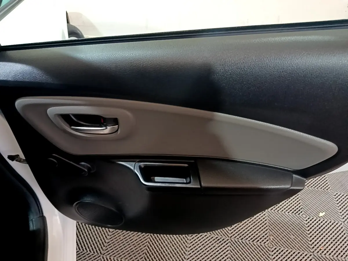 Vue rapprochée de la porte arrière gauche intérieure noire et grise d'une Toyota Yaris blanche 2019.