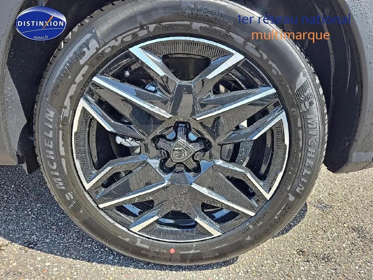 Gros plan sur la jante alu noire et chromée du Peugeot 3008 noir perla nera, mettant en valeur le logo central lion.