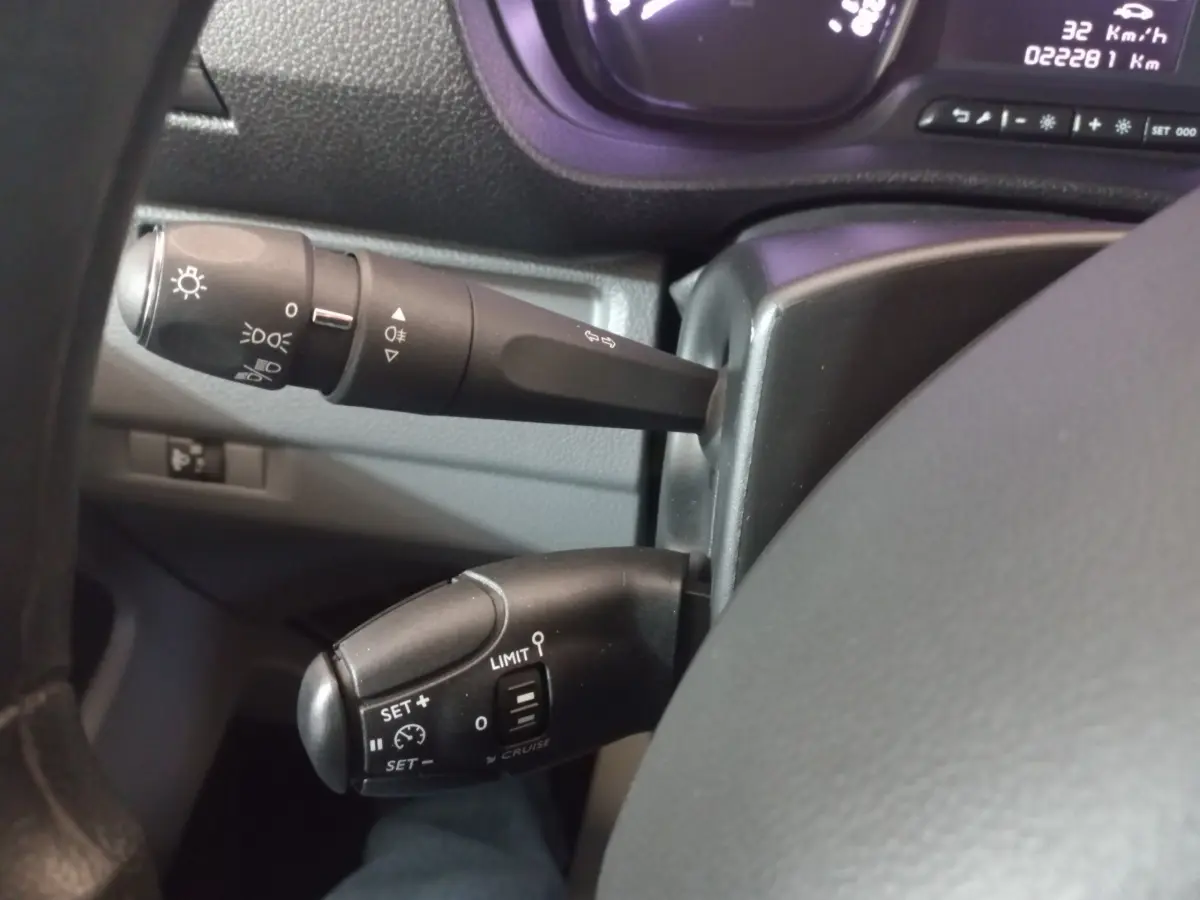 Gros plan sur les commandes au volant du Peugeot Traveller 2021, avec levier de clignotant et régulateur de vitesse.