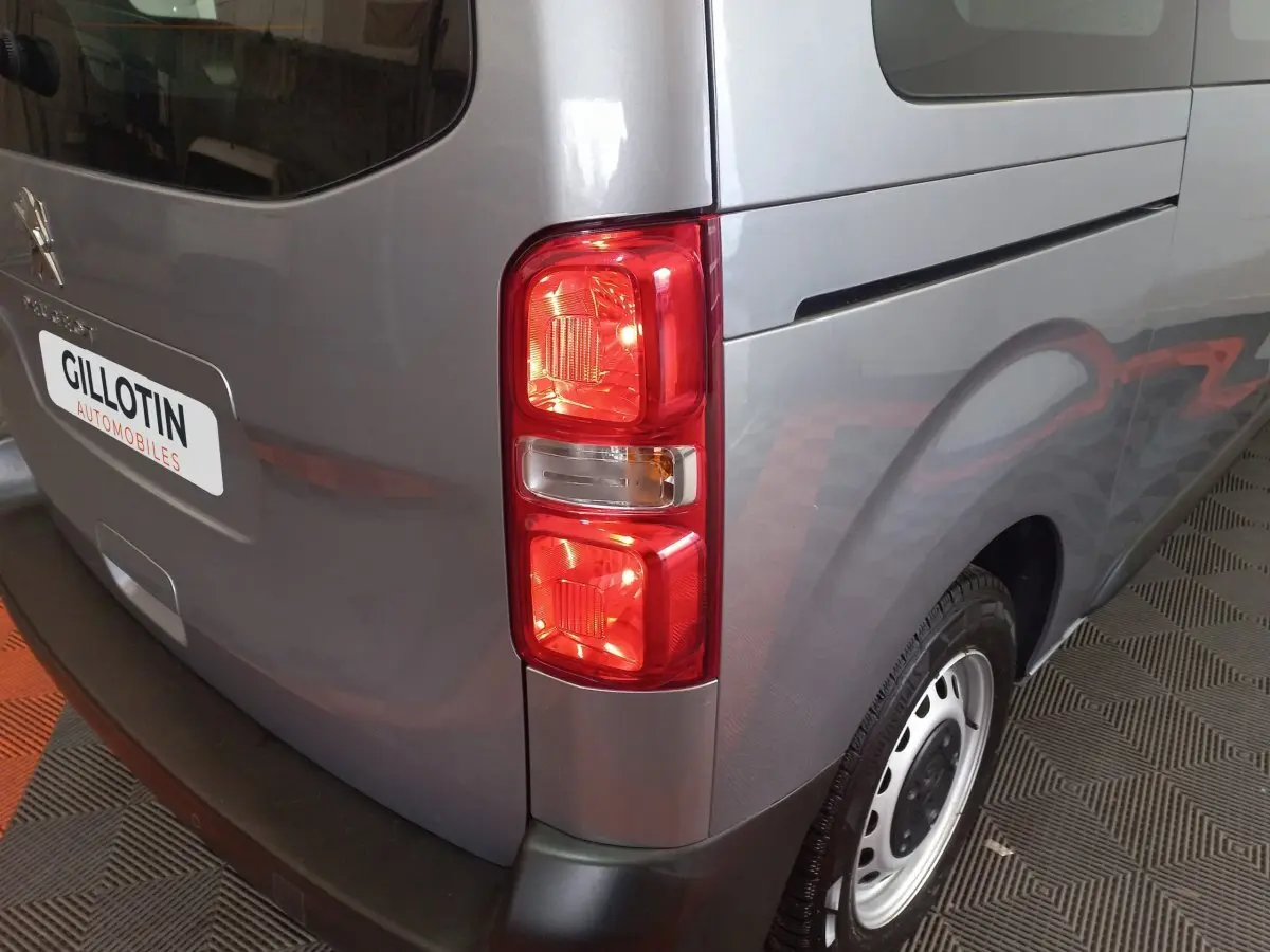 Vue arrière droite du Peugeot Traveller gris clair 2021, mettant en valeur le feu arrière et la roue acier.