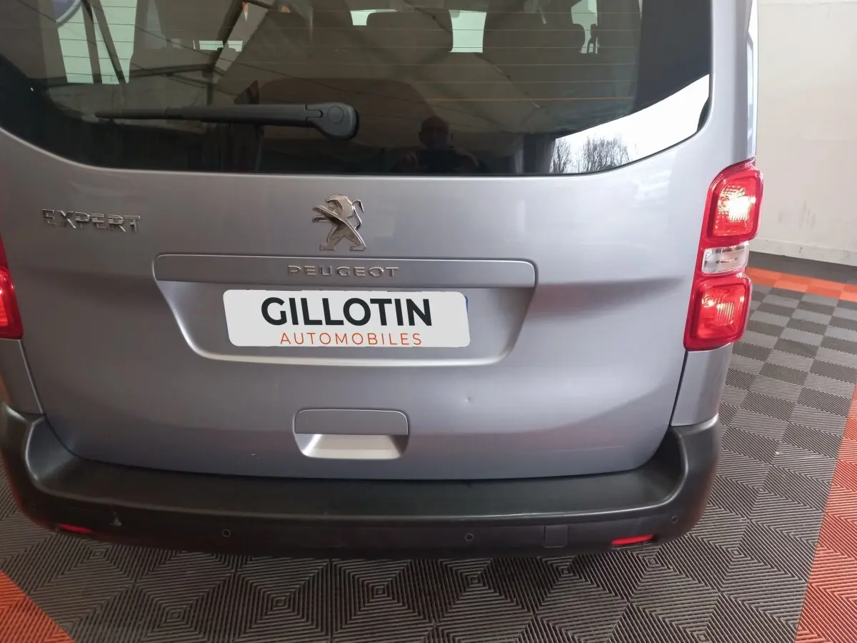 Vue arrière d'un Peugeot Expert gris clair avec logo et plaque d'immatriculation GILLOTIN AUTOMOBILES visible.