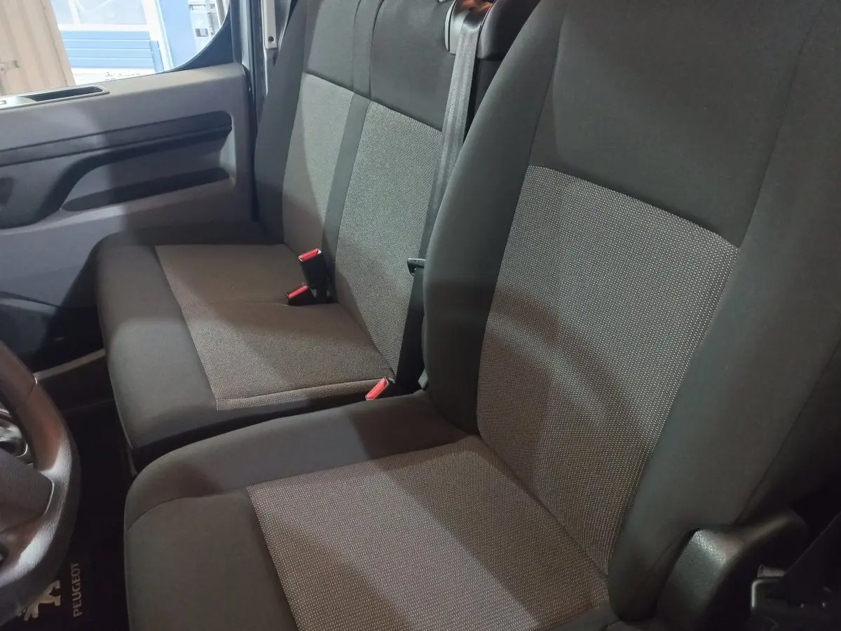 Vue intérieure rapprochée des sièges avant gris foncé du Peugeot Traveller 2021, côté conducteur et passager.