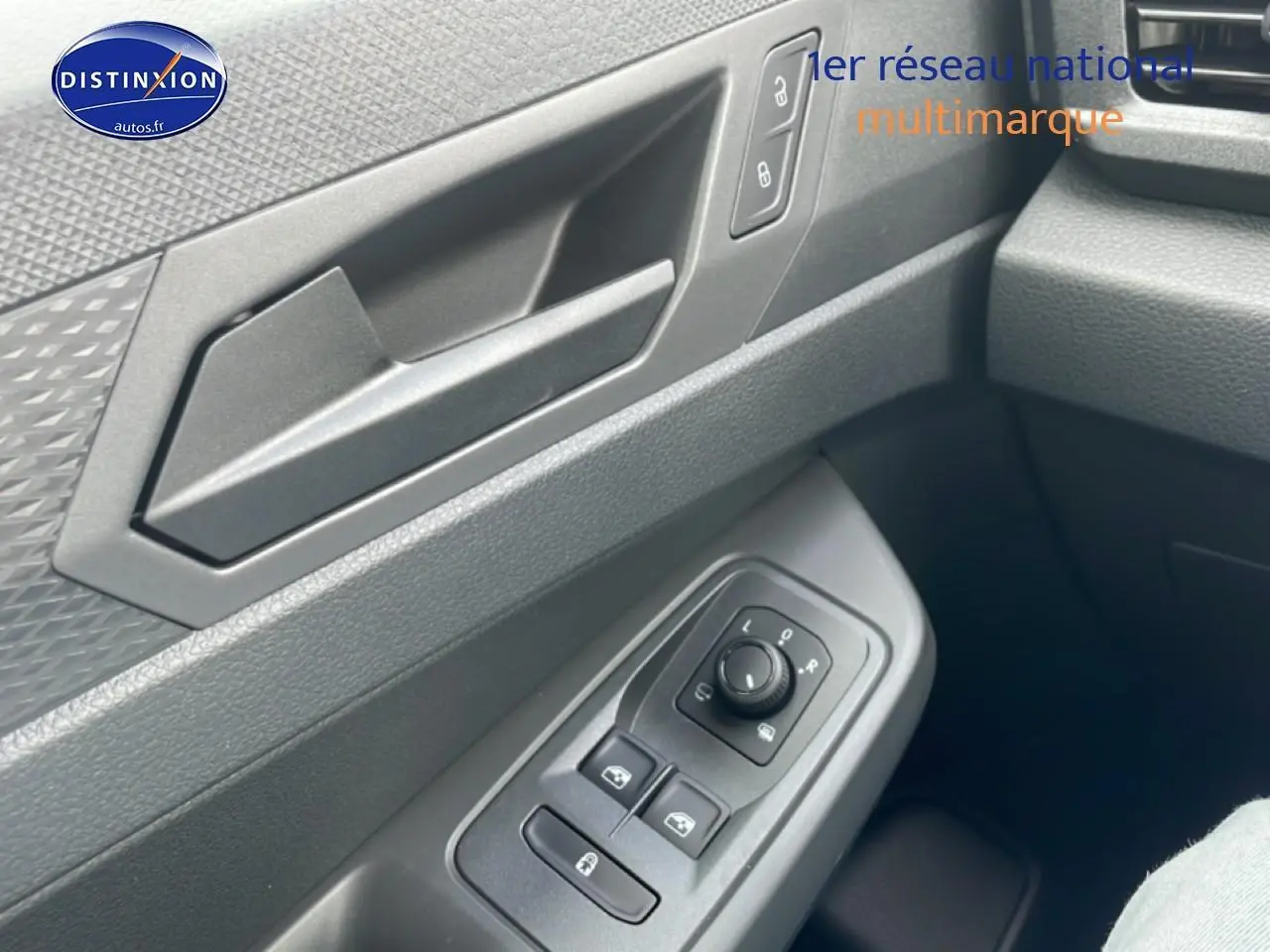 Détail de la porte côté conducteur du Volkswagen Caddy gris indien 2025 avec commandes électriques des vitres et rétroviseurs.