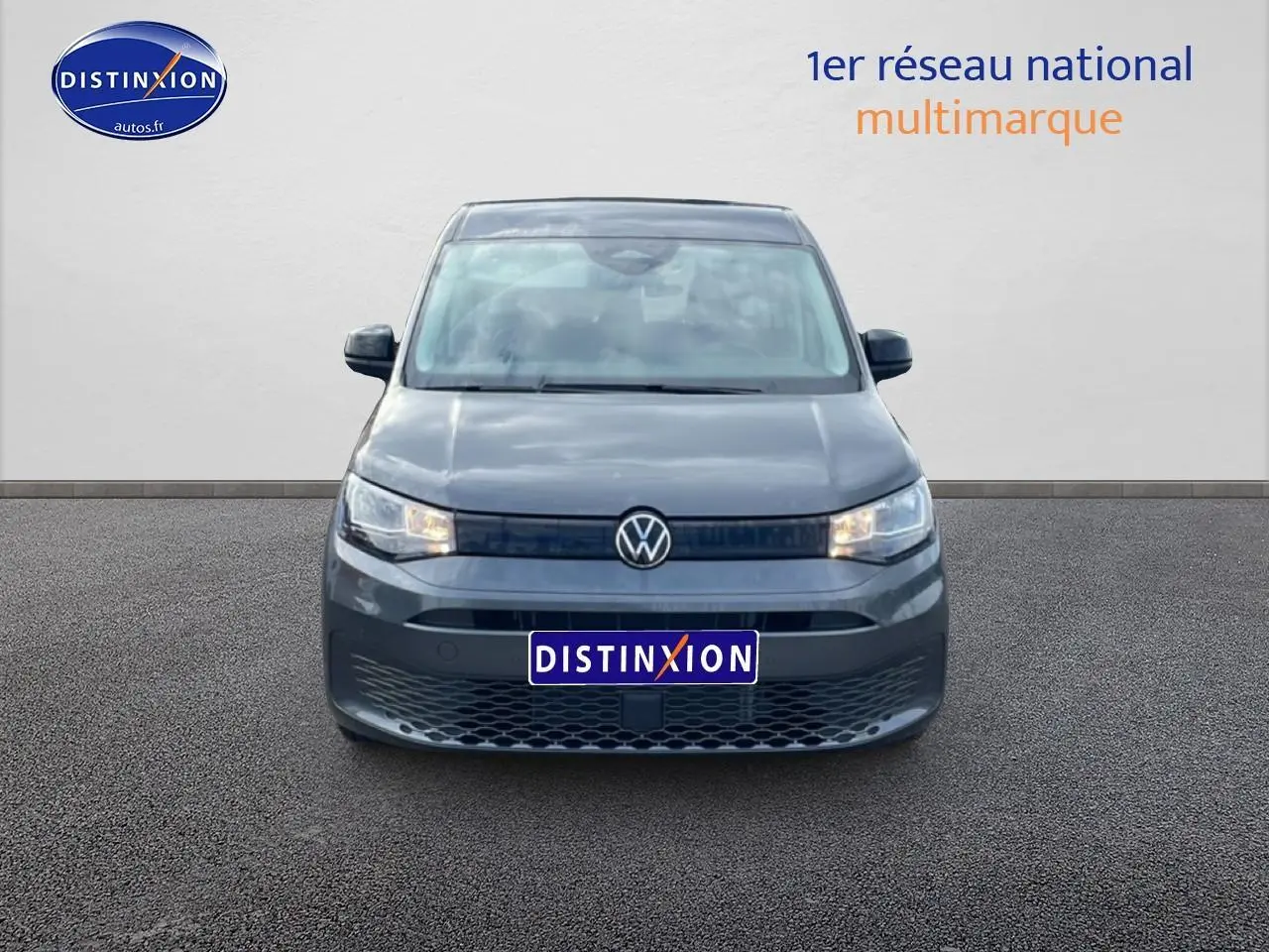 Vue de face du Volkswagen Caddy gris indien 2025 avec calandre noire et logo VW centré.