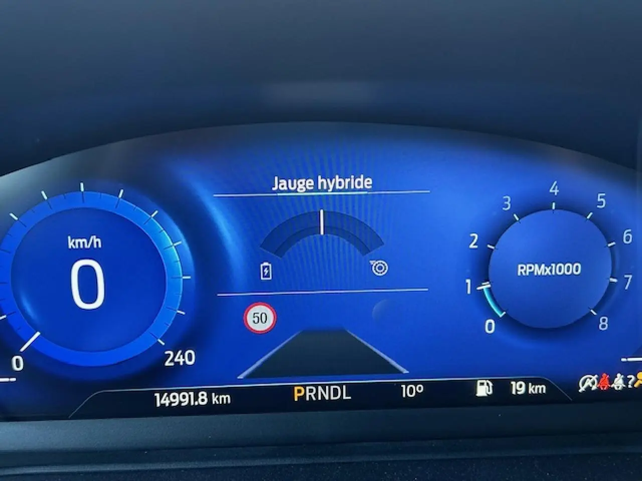 Combiné d'instrumentation numérique bleu de la Ford Puma 2023 avec jauge hybride et affichage vitesse à 0 km/h.
