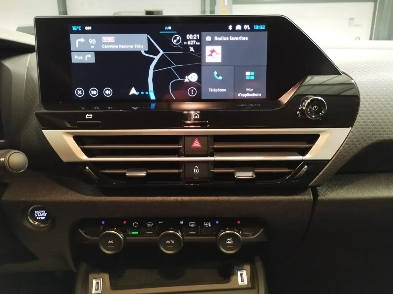 Vue rapprochée du tableau de bord de la Citroën C4 2025, écran tactile central et commandes climatisation visibles.