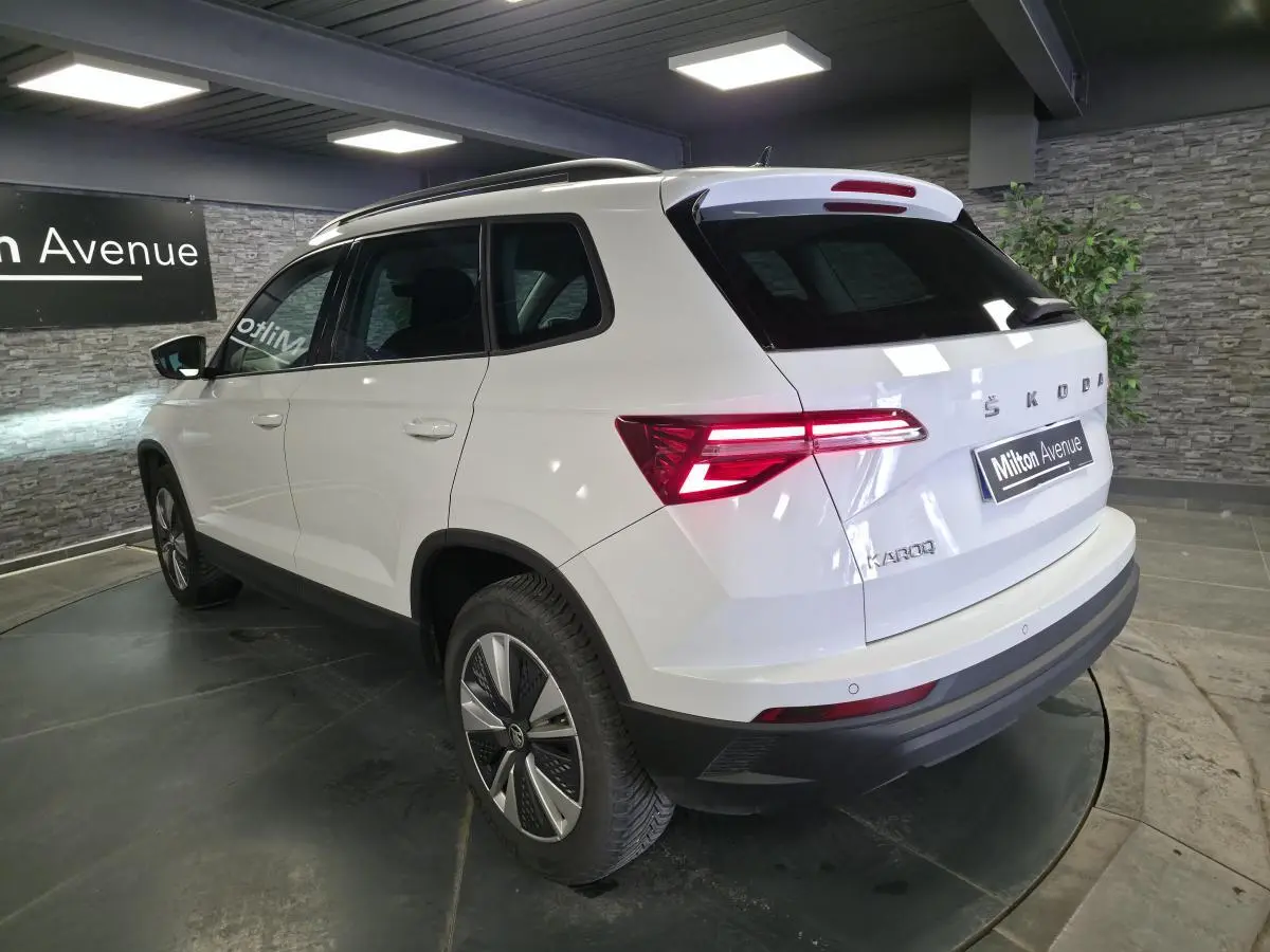 Vue 3/4 arrière droite du Skoda Karoq blanc 2023 avec feux arrière LED et jantes alliage 17 pouces.
