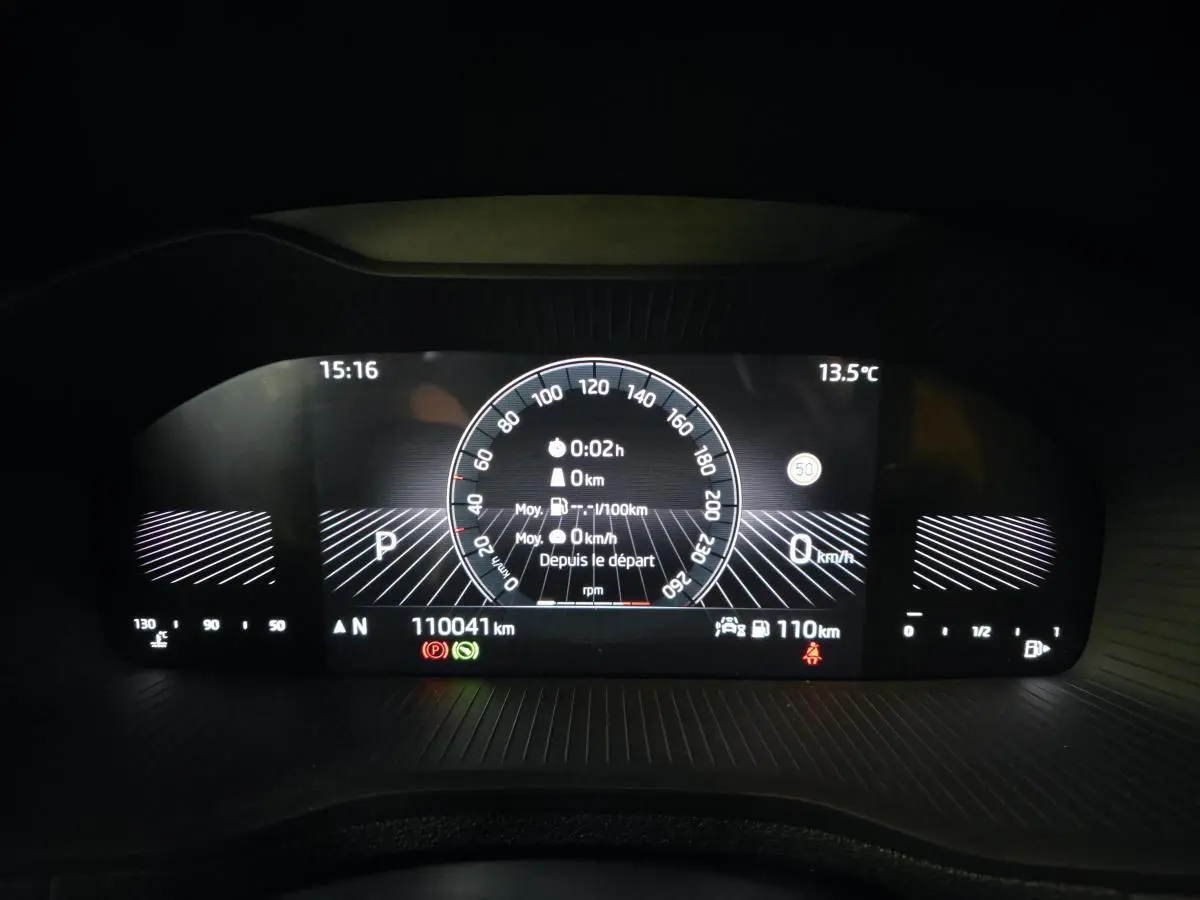 Tableau de bord numérique du Skoda Karoq blanc 2023, affichage vitesse, température et autonomie.