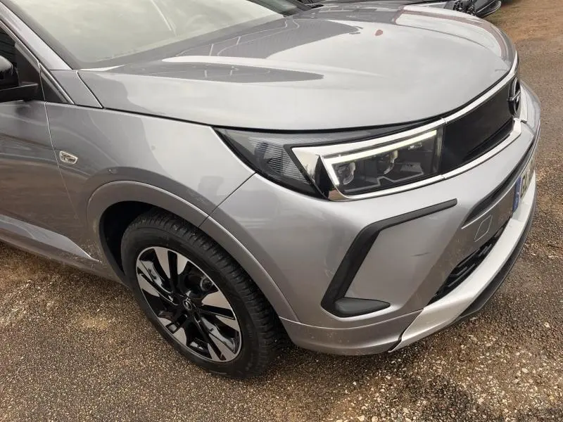 Vue 3/4 avant droit d'un Opel Grandland gris Kontrast Métallisé avec phares LED et jantes alliage noires.