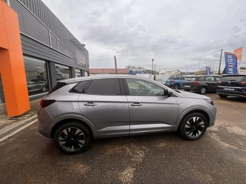Vue latérale droite d'un Opel Grandland 2022 gris Kontrast métallisé avec jantes alu noires et vitres surteintées.