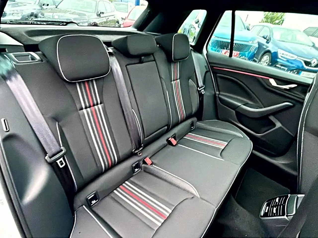 Vue intérieure côté droit de la banquette arrière noire avec surpiqûres rouges et blanches du Skoda Kamiq Monte Carlo 2026.