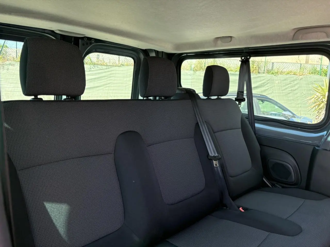 Banquette arrière trois places en tissu noir vue côté droit dans le Renault Trafic Fourgon Urban Grey 2024.