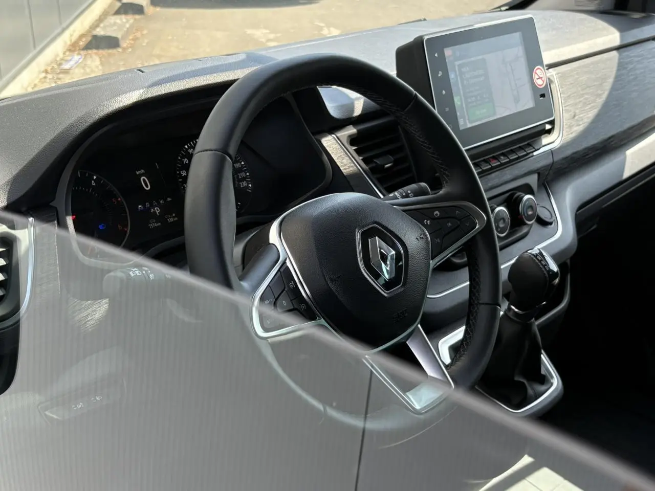 Intérieur du Renault Trafic Fourgon 2024 vu côté conducteur, volant multifonction et écran tactile 8 pouces en évidence.