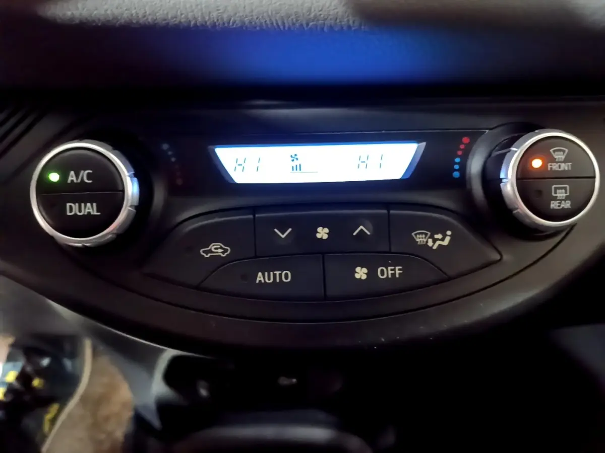 Vue rapprochée du panneau de climatisation 2 zones de la Toyota Yaris hybride 2019 avec affichage digital et boutons lumineux.