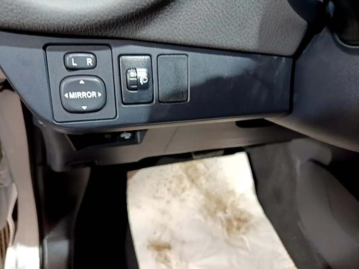 Gros plan sur les commandes de réglage des rétroviseurs côté conducteur de la Toyota Yaris blanche 2019.