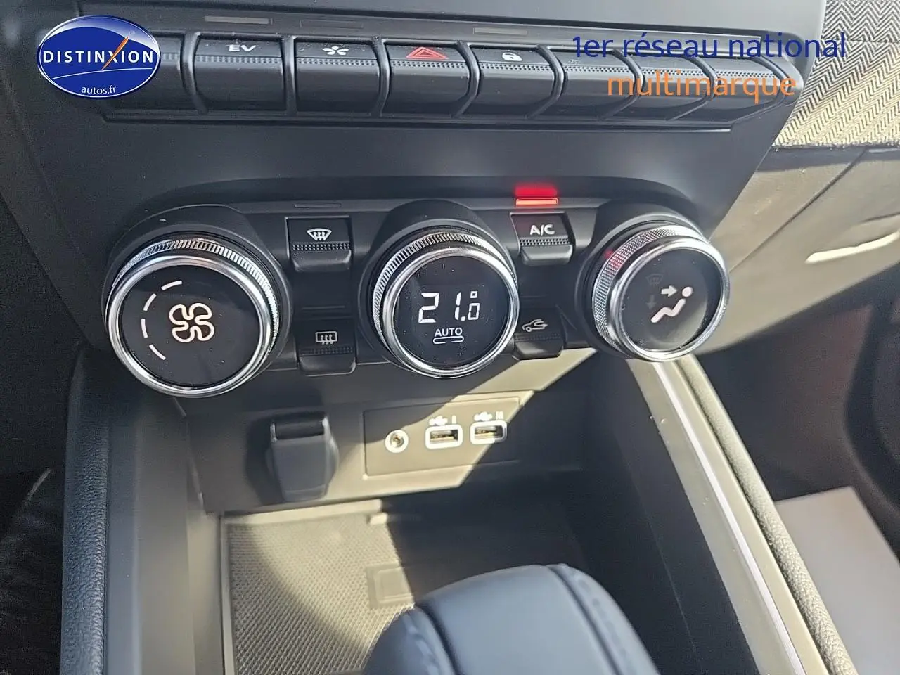 Gros plan sur les commandes de climatisation et les ports USB du Renault Clio V 1.6 e-tech 145 techno, intérieur noir.