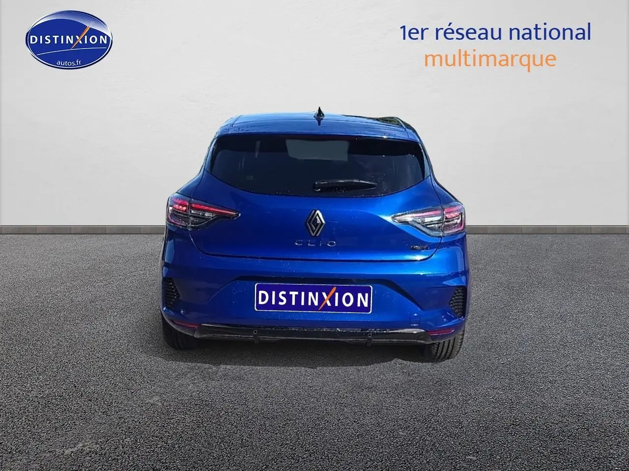 Vue arrière d'une Renault Clio V bleu iron avec feux LED et lunette arrière surteintée sur fond neutre.